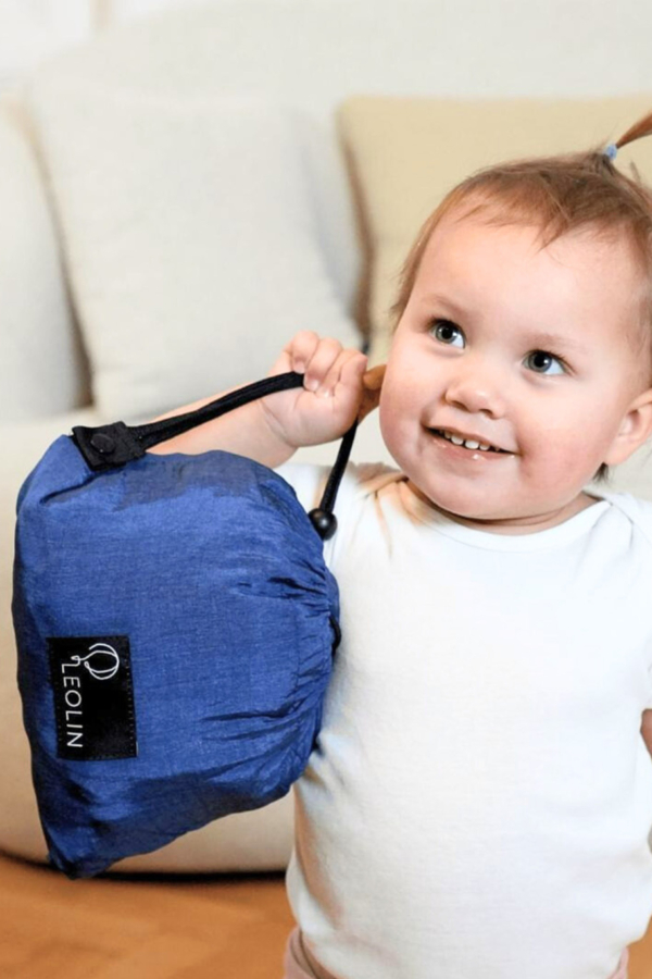 Baby mit Tasche von Babytrage Leolin Maxi Navy Blue Melange in der Hand